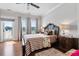 Well-lit bedroom featuring hardwood floors, a ceiling fan, and door to the patio at 8964 Palmetto Rd, Edisto Island, SC 29438
