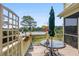 Outdoor deck overlooking the water, featuring a table, umbrella, and privacy screen at 8964 Palmetto Rd, Edisto Island, SC 29438