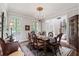 Traditional dining room with wood table, chandelier, rug and windows with shutters at 8964 Palmetto Rd, Edisto Island, SC 29438