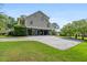 Rear exterior view of the charming home featuring a gravel drive and ground level parking at 8964 Palmetto Rd, Edisto Island, SC 29438