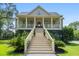 Stately two-story home featuring a grand staircase and inviting front porch with classic columns at 8964 Palmetto Rd, Edisto Island, SC 29438