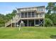 Exterior rear view showcasing a multi-level deck with outdoor seating and a view of the lush backyard at 8964 Palmetto Rd, Edisto Island, SC 29438