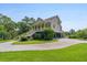 Beautifully landscaped home with a gravel driveway, lush lawn, and well-manicured shrubbery at 8964 Palmetto Rd, Edisto Island, SC 29438