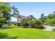 Beautiful home with a large, green front yard, palm trees, and a circular driveway at 8964 Palmetto Rd, Edisto Island, SC 29438