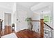 Upstairs hallway features hardwood floors, black iron railings, and a decorative vase at 8964 Palmetto Rd, Edisto Island, SC 29438