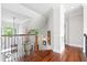Elegant hallway featuring wood floors, iron railings, and natural light at 8964 Palmetto Rd, Edisto Island, SC 29438