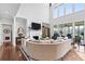 Cozy living room featuring a fireplace, high ceilings, and access to a sunroom overlooking the water at 8964 Palmetto Rd, Edisto Island, SC 29438