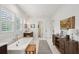 Bright bathroom featuring a soaking tub, wooden vanity, and modern fixtures at 924 Mciver St, Mount Pleasant, SC 29464