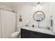 Bathroom with a modern vanity, marble countertop, round mirror, and shower/tub combination at 924 Mciver St, Mount Pleasant, SC 29464