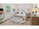Bright bedroom with neutral tones, a wicker headboard, side tables, and shuttered windows at 924 Mciver St, Mount Pleasant, SC 29464