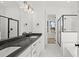 Modern bathroom featuring a double vanity, black countertop, and glass enclosed shower and tub at 100 E Carolina Ave, Summerville, SC 29483