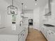 Modern kitchen featuring a large island, white cabinets, stainless steel appliances, and pendant lighting at 100 E Carolina Ave, Summerville, SC 29483