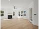 Bright living room with a fireplace, large windows, light wood floors and a ceiling fan at 100 E Carolina Ave, Summerville, SC 29483
