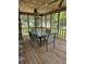 Covered back porch featuring wood ceiling, ceiling fan, screens, and an outdoor dining set at 101 Brittany Ct, Summerville, SC 29485