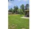 Expansive back yard with lush green grass, wooden privacy fence, mature trees, and screened back porch at 101 Brittany Ct, Summerville, SC 29485