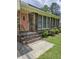 Close-up of the home's entrance, featuring a brick facade, a pink front door and manicured landscaping at 101 Brittany Ct, Summerville, SC 29485