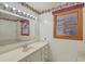 Bathroom with white countertops, a mirror, and a window with custom window coverings at 1023 Striper Ave, Moncks Corner, SC 29461