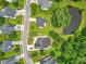 Aerial view of a neighborhood featuring well-maintained lawns, mature trees, and a community pond at 107 Oakbluff Rd, Summerville, SC 29485