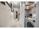 Bright hallway with adjacent laundry room, fitted with modern washer, dryer, and ample storage shelving at 107 Oakbluff Rd, Summerville, SC 29485