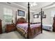 A bedroom featuring a four-poster bed, tray ceiling, neutral carpet, and side tables with lamps at 107 Oakbluff Rd, Summerville, SC 29485