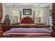 Close-up of a bedroom showcasing a four-poster bed, side tables with lamps, and large windows at 107 Oakbluff Rd, Summerville, SC 29485