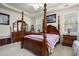 Bedroom with four-poster bed, tray ceiling, bedside tables, and windows bringing in natural light at 107 Oakbluff Rd, Summerville, SC 29485