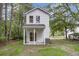 Backyard view of home with covered porch, grassy lawn, and mature trees at 110 Farm Rd # A, Goose Creek, SC 29445