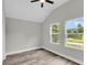 Bedroom with two windows offering treetop views and hardwood flooring; ceiling fan included at 110 Farm Rd # A, Goose Creek, SC 29445