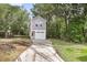 Two-story home with gray siding, white trim, attached garage, and a concrete driveway surrounded by lush greenery at 110 Farm Rd # A, Goose Creek, SC 29445