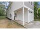 Side angle of a home with gray and white siding, a small covered porch, and a neatly-numbered entrance at 110 Farm Rd # A, Goose Creek, SC 29445