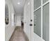 Bright hallway with wood-look floors, decorative rug, white doors, and a view to living spaces at 110 Farm Rd # A, Goose Creek, SC 29445