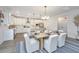 Elegant dining area showcasing a rustic wood table and white upholstered chairs alongside a modern kitchen at 111 Augusta Pass Dr, Ridgeville, SC 29472