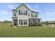 Beautiful two-story home showcasing a well-manicured lawn, stone accents, and black shutters under a bright blue sky at 111 Augusta Pass Dr, Ridgeville, SC 29472