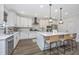 Kitchen features white cabinetry, quartz counters, stainless appliances and island with seating at 111 Augusta Pass Dr, Ridgeville, SC 29472