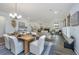 Open-concept living space with a rustic wood dining table, fireplace, and neutral color palette at 111 Augusta Pass Dr, Ridgeville, SC 29472