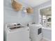 Functional laundry room featuring modern washer and dryer with natural light and shelving at 112 Orchard Blossom Ln, Summerville, SC 29485