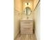 Modern bathroom with a wooden vanity, silver hardware, wainscotting, and round mirror at 113 Rockdale Ln, Goose Creek, SC 29445