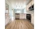 Well-lit kitchen with stainless steel appliances, white cabinets, and laminate floors, offering a modern and sleek design at 113 Rockdale Ln, Goose Creek, SC 29445