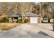 Single-story brick home featuring an attached garage, a driveway, and mature trees at 113 Surrey Dr, Summerville, SC 29486