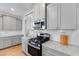 Close-up of a kitchen showcasing stainless steel appliances, gray cabinets, and granite countertops at 114 Orchard Blossom Ln, Summerville, SC 29485