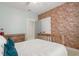 Bedroom featuring exposed brick accent wall, wood bed frame, and neutral color palette at 115 Winding Branch Dr, Summerville, SC 29486