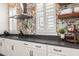 Close up of kitchen with white cabinets, stone countertops, and stainless steel range hood at 115 Winding Branch Dr, Summerville, SC 29486