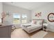 Well-lit bedroom featuring a bed, gray desk, and views of the surrounding neighborhood at 1150 Cooper Point St, Summerville, SC 29485