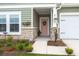 Inviting front porch with stone accents, a decorative wreath, and lush landscaping at 1150 Cooper Point St, Summerville, SC 29485