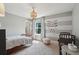 Bright bedroom with two beds, a decorative light fixture, striped walls, and a cozy reading chair at 1164 Sharpestowne Ct, Mount Pleasant, SC 29466