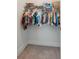 White closet with a variety of hanging clothes, and plastic organizing baskets at 1164 Sharpestowne Ct, Mount Pleasant, SC 29466