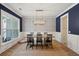 Elegant dining room featuring designer wallpaper, wood table, and stylish light fixture at 1164 Sharpestowne Ct, Mount Pleasant, SC 29466