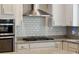 Close-up of stainless steel oven and a gas cooktop with granite countertops and a white subway tile backsplash at 1164 Sharpestowne Ct, Mount Pleasant, SC 29466