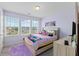 Comfortable bedroom featuring three windows, a colorful comforter, and soft lavender walls at 123 Lyra Ln, Summerville, SC 29486
