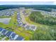 An aerial view showcases a vibrant community with lush greenery, a tranquil lake, and neatly arranged homes at 135 Cypress Preserve Blvd, Moncks Corner, SC 29461